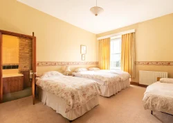 3 single beds and a camp bed in the Foxglove bedroom