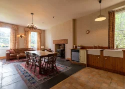 The Kitchen showing a wooden dining table, sofa and log burner