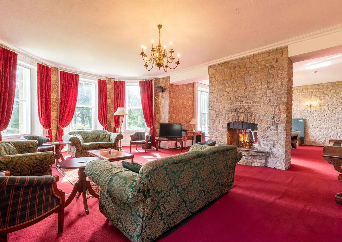 The lounge at Cholwell Hall showing a seating area, a fireplace and coffee table